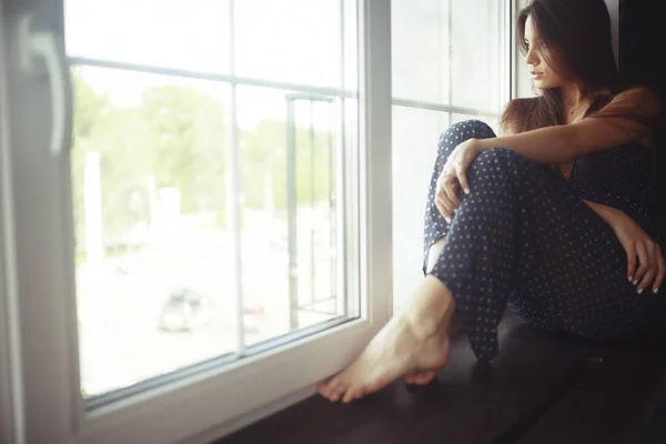 Young woman on windowsill — Stock Photo, Image