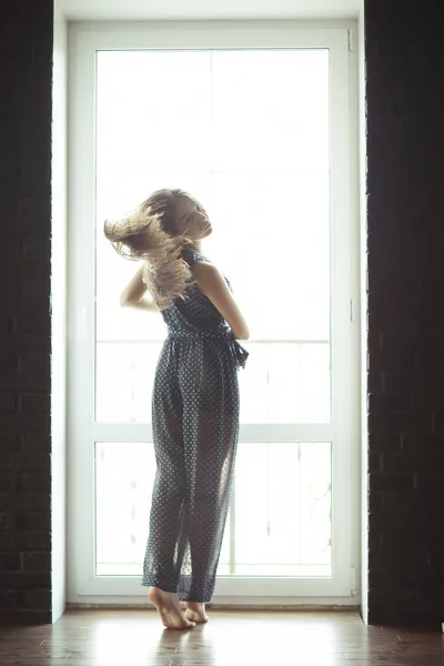 Kvinna som står mot fönster — Stockfoto