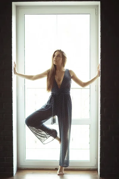 Wanita yang berdiri melawan jendela — Stok Foto