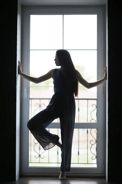 Woman standing against window — Stock Photo, Image