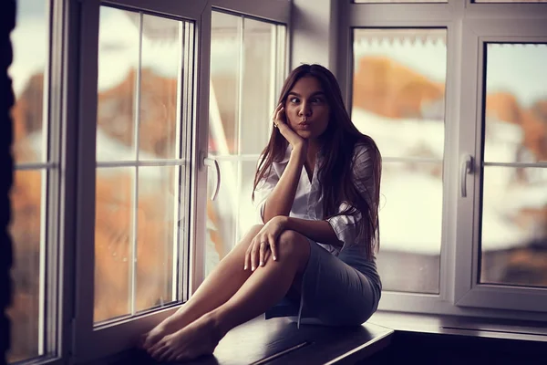 Mujer joven en alféizar de la ventana —  Fotos de Stock