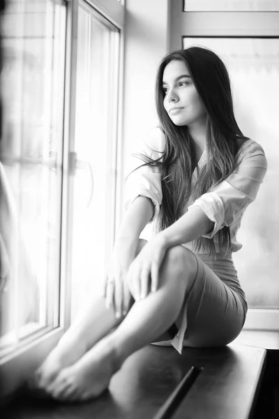 Ung kvinna på fönsterbräda — Stockfoto