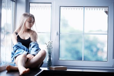 Pencere kenarında oturan kadın