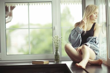 Pencere kenarında oturan kadın