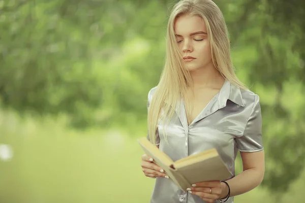 Jovem mulher segurando livro no parque — Fotografia de Stock