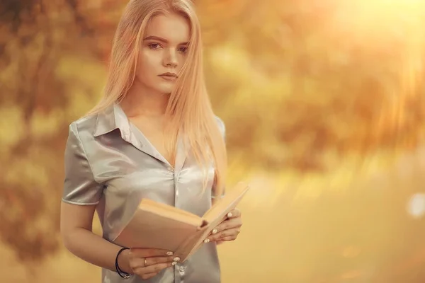Молодая женщина с книгой в парке — стоковое фото