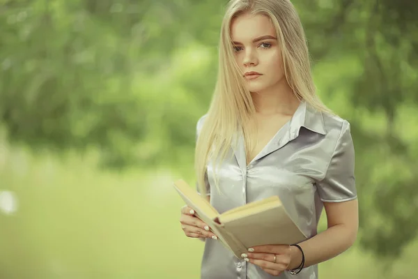 Genç kadın holding kitap Park — Stok fotoğraf