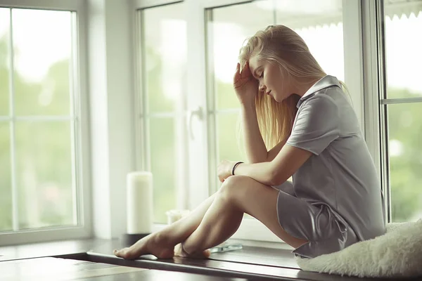 Junge Frau auf Fensterbank — Stockfoto