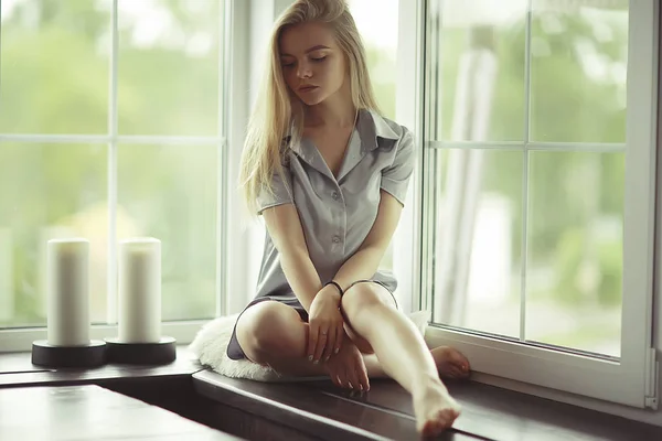 Mujer joven en alféizar de la ventana —  Fotos de Stock