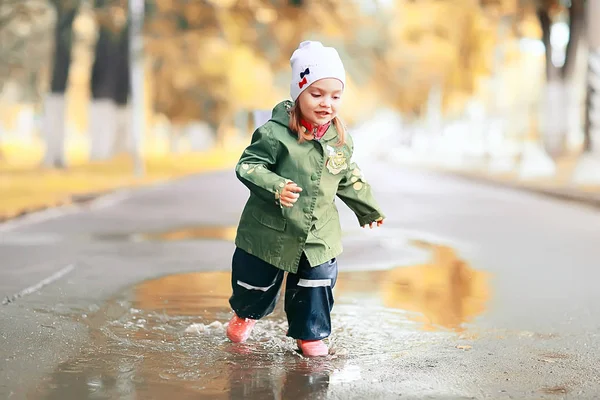 Маленькая девочка в райном парке — стоковое фото