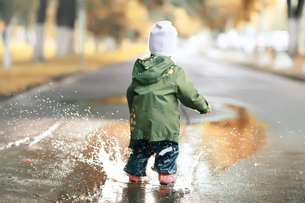 Klein meisje in regenachtige park — Stockfoto