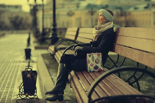 Молодая женщина сидит на скамейке — стоковое фото