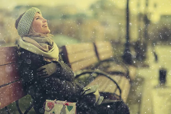 Genç kadın bankta oturuyor.