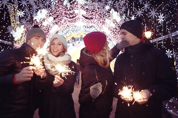 Pessoas com faíscas celebrando o Natal — Fotografia de Stock