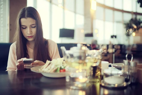 Woman using smartphone in cafe — Stock Photo, Image