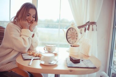 Parlak bir kafede sabah kahvaltısı, genç bir mankenin samimi bir portresi, evde yaşam tarzı.