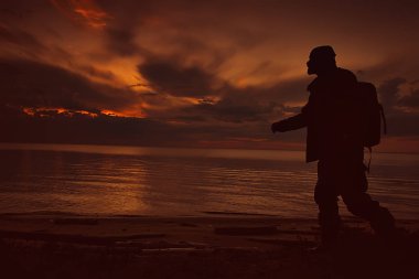 Gölün kenarında gezgin bir adam, kampanyadaki bir adamın silueti, faaliyet