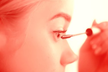 Kirpikli kız, genç güzel sarışın kirpikleri boyuyor, sabahları evde maskara sürüyor.