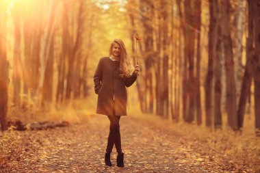 Manken sonbahar yürüyüşü sarı park romantizmi güzel genç yetişkin modeli sonbahar parkının sarı manzarasında poz veriyor.