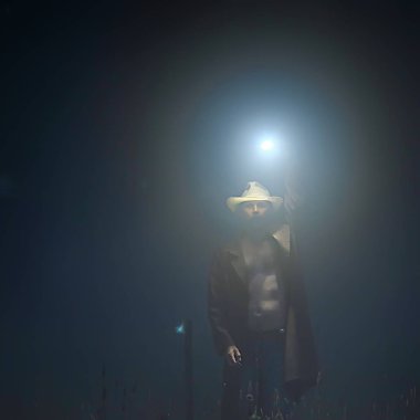 Siste korku, tarlada fener tutan adam, cadılar bayramı manzarası, korku konsepti.