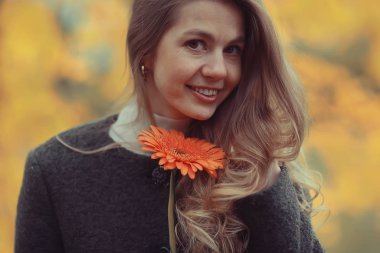 Tek çiçekli güzel bir sarışının sonbahar portresi, manken pozitiftir.