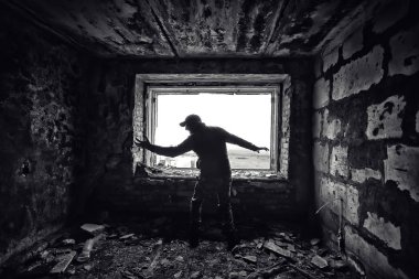 Mahvolmuş bir evin arka planında bir adam, korku, korku konsepti, Çernobil zombi kıyametinde radyasyon takipçisi