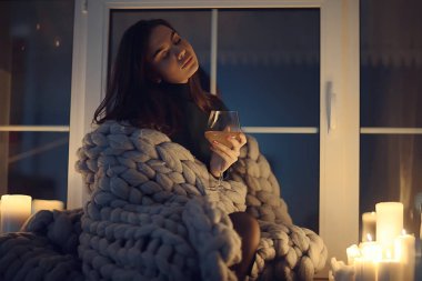 Pencerenin önünde battaniyede oturan kız, mumlar gece, yalnızlık, genç yalnız kız, stres