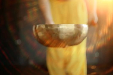 Tibet şarkı kasesi, sarı pantolonlu bir keşiş meditasyon yapar ve müzik kasesi, Budizm ve din çalar.