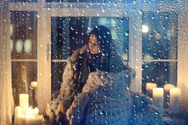 Pencerenin önünde battaniyede oturan kız, mumlar gece, yalnızlık, genç yalnız kız, stres