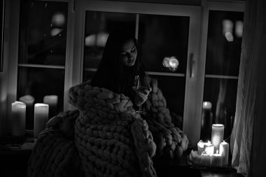 Pencerenin önünde battaniyede oturan kız, mumlar gece, yalnızlık, genç yalnız kız, stres