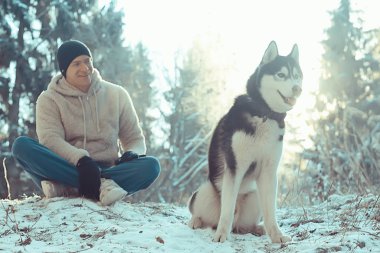 Köpekli bir adam kış ormanlarında yürüyüşe çıkıyor, güneşli bir Noel manzarası, parkta yaşayan insanlar ve köpekler.