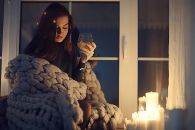 Pencerenin önünde battaniyede oturan kız, mumlar gece, yalnızlık, genç yalnız kız, stres