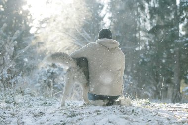 man and dog are sitting with their backs to the frame, the concept of psychology is sadness, caring friendship