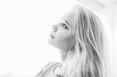 Genç, sarışın, uzun saçlı, şık bir model stüdyoda poz veriyor.