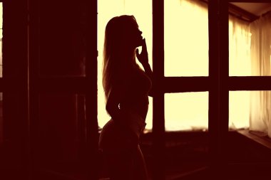 Çatı katının içinde seksi bir model. Güneşin arka aydınlatma ışınları.