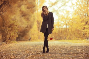 Manken sonbahar yürüyüşü sarı park romantizmi güzel genç yetişkin modeli sonbahar parkının sarı manzarasında poz veriyor.