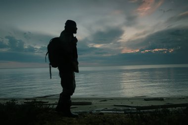 Gölün kenarında gezgin bir adam, kampanyadaki bir adamın silueti, faaliyet