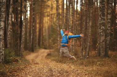 Yürüyüşe beni takip edin, bir adam sizi orman yürüyüşüne davet ediyor, doğadaki sonbahar manzarası.