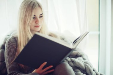 Ekose örülü pencere kızı kitap okuyor, genç kadın evde okuyor, romantizm, öğrenim, öğrenci, sonbahar iç mimarisi.