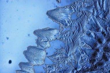 Mavi buzlu cam arka plan, buzun yüzeyinin soyut dokusu, donmuş mevsimlik su.