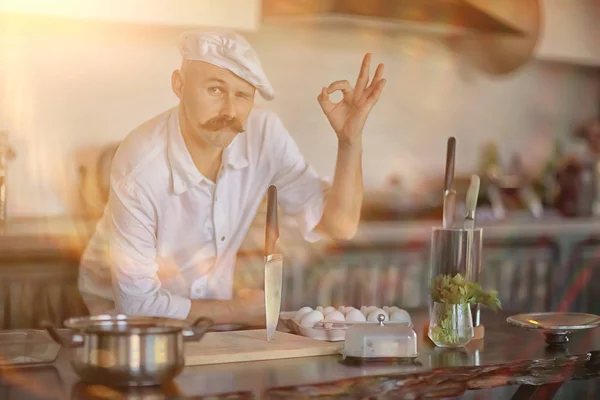 french chef in the kitchen preparing food, cooking, haute cuisine, man with mustache