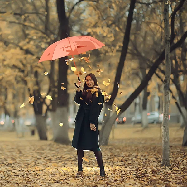 autumn evening woman holds umbrella, october in dark city park, young lonely model with umbrella