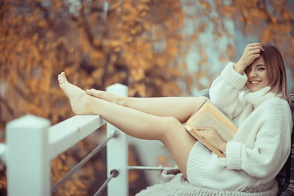 穿着针织毛衣的女孩在公园里读一本关于阳台的书 关于季节浪漫的概念 — 图库照片