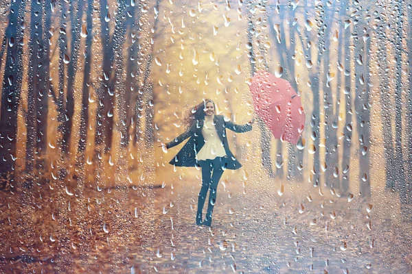 autumn rain woman, beautiful model in the rain in a city park, autumn warm tones, yellow leaves, autumn weather concept