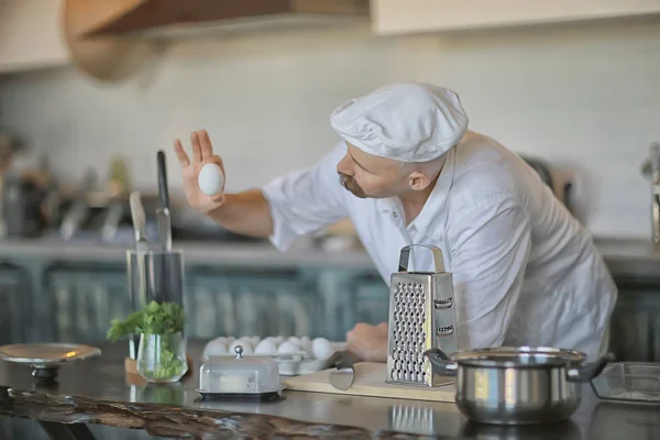 french chef in the kitchen preparing food, cooking, haute cuisine, man with mustache