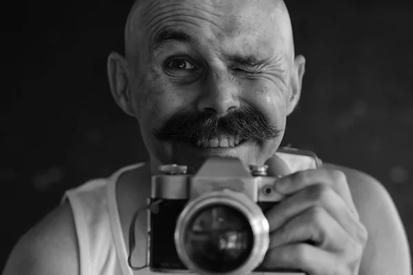 ヴィンテージアナログカメラを持った写真家口ひげを生やした面白い写真を学ぶ男 — ストック写真