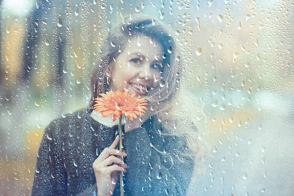 autumn rain woman, beautiful model in the rain in a city park, autumn warm tones, yellow leaves, autumn weather concept