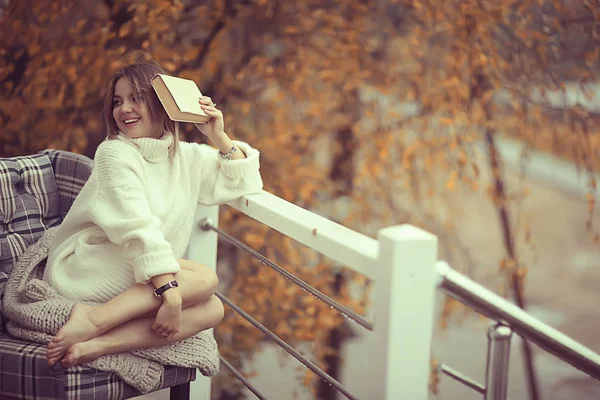穿着针织毛衣的女孩在公园里读一本关于阳台的书 关于季节浪漫的概念 — 图库照片
