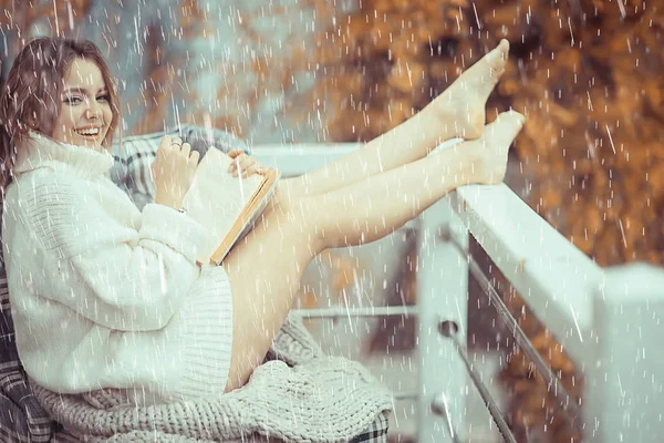女孩带着一本书在秋天的雨中在阳台上的房子 季节性的肖像画浪漫的秋天与雨 天降雨滴 — 图库照片