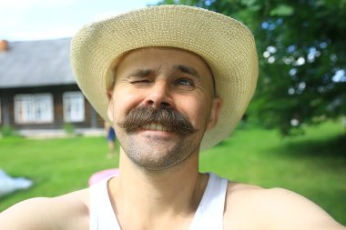 Bıyıklı genç çiftçi, şapkalı büyük bıyıklı bir adamın portresi.